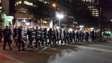 8:52pm: Police walked down Trade Street toward the Omni Hotel in downtown Charlotte 9/21/16 after violence broke out during protests over the killing of Keith Scott. (David Boraks/WFAE)
